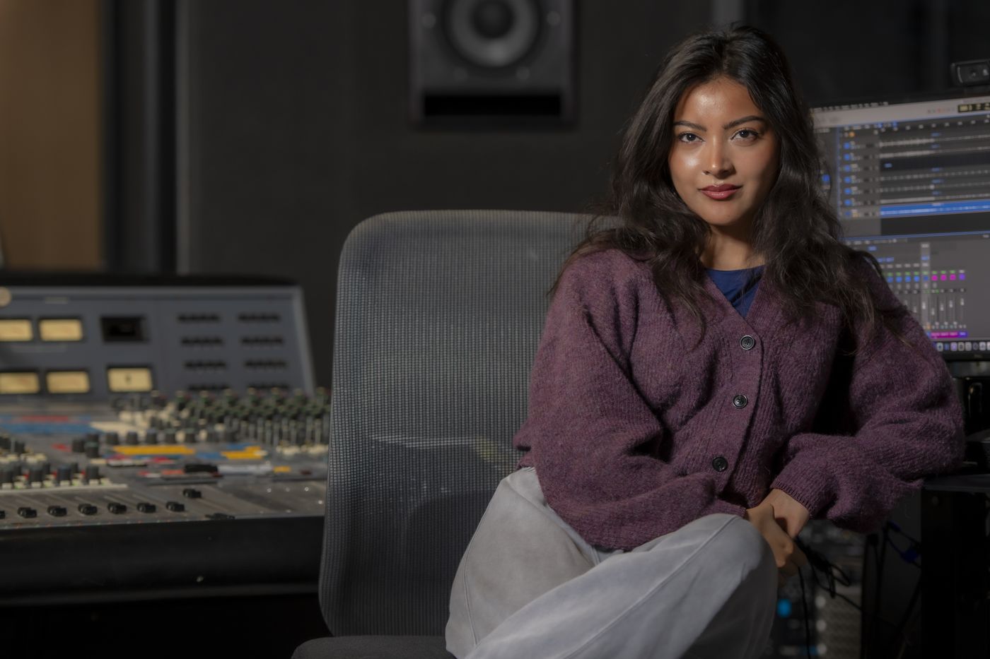 Belle Garcia, recording engineer, in a studio control room beside the mixing console